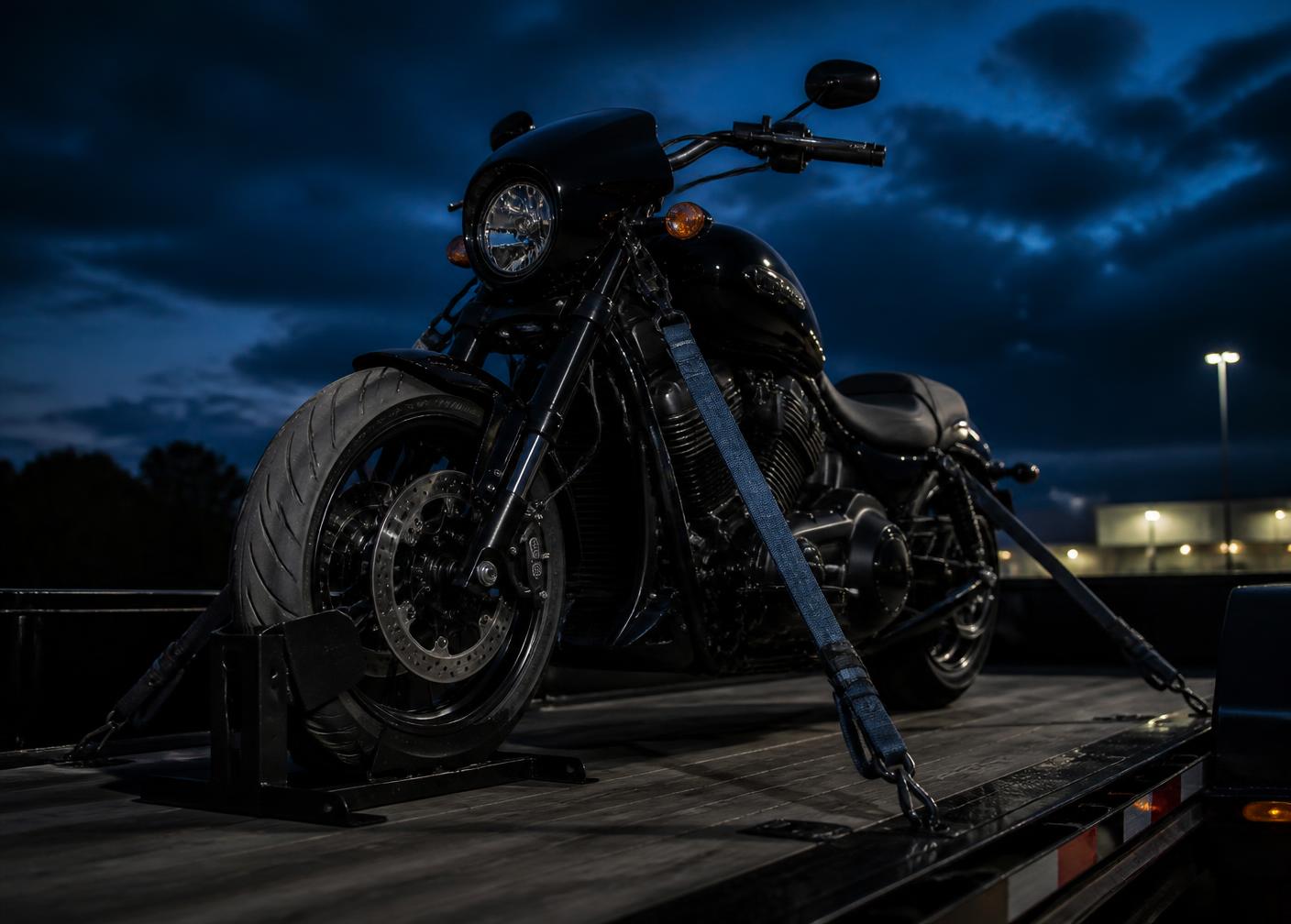 Motorcycle secured with soft straps and a wheel chock on a transport trailer deck